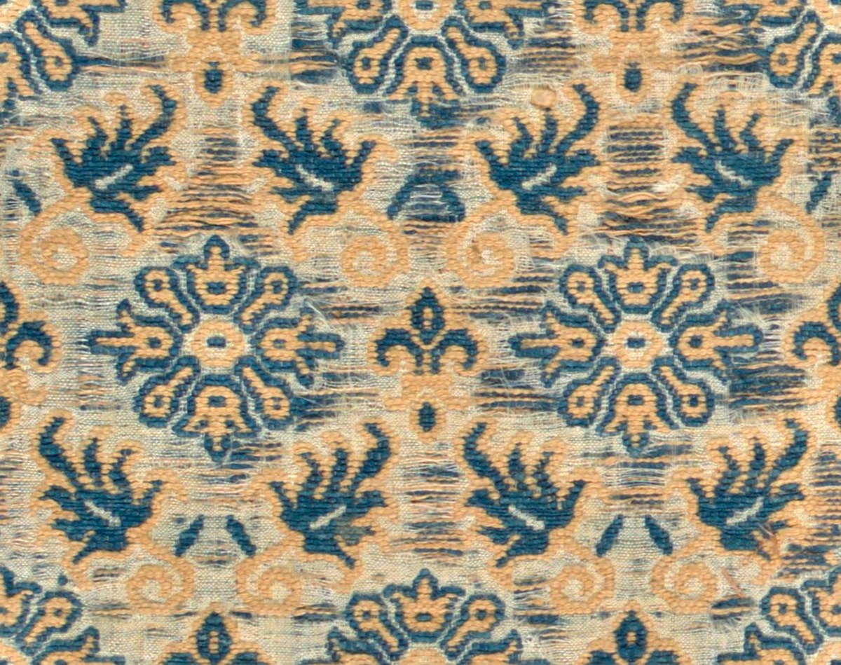 A seamless fabric texture with flower motif woven textile units arranged in a None pattern