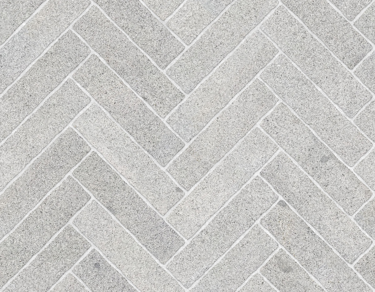 A seamless stone texture with granite blocks arranged in a Herringbone pattern